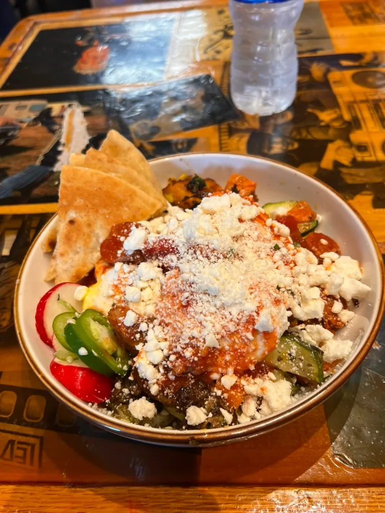 A bowl of sausage shakshuka with feta and pitta